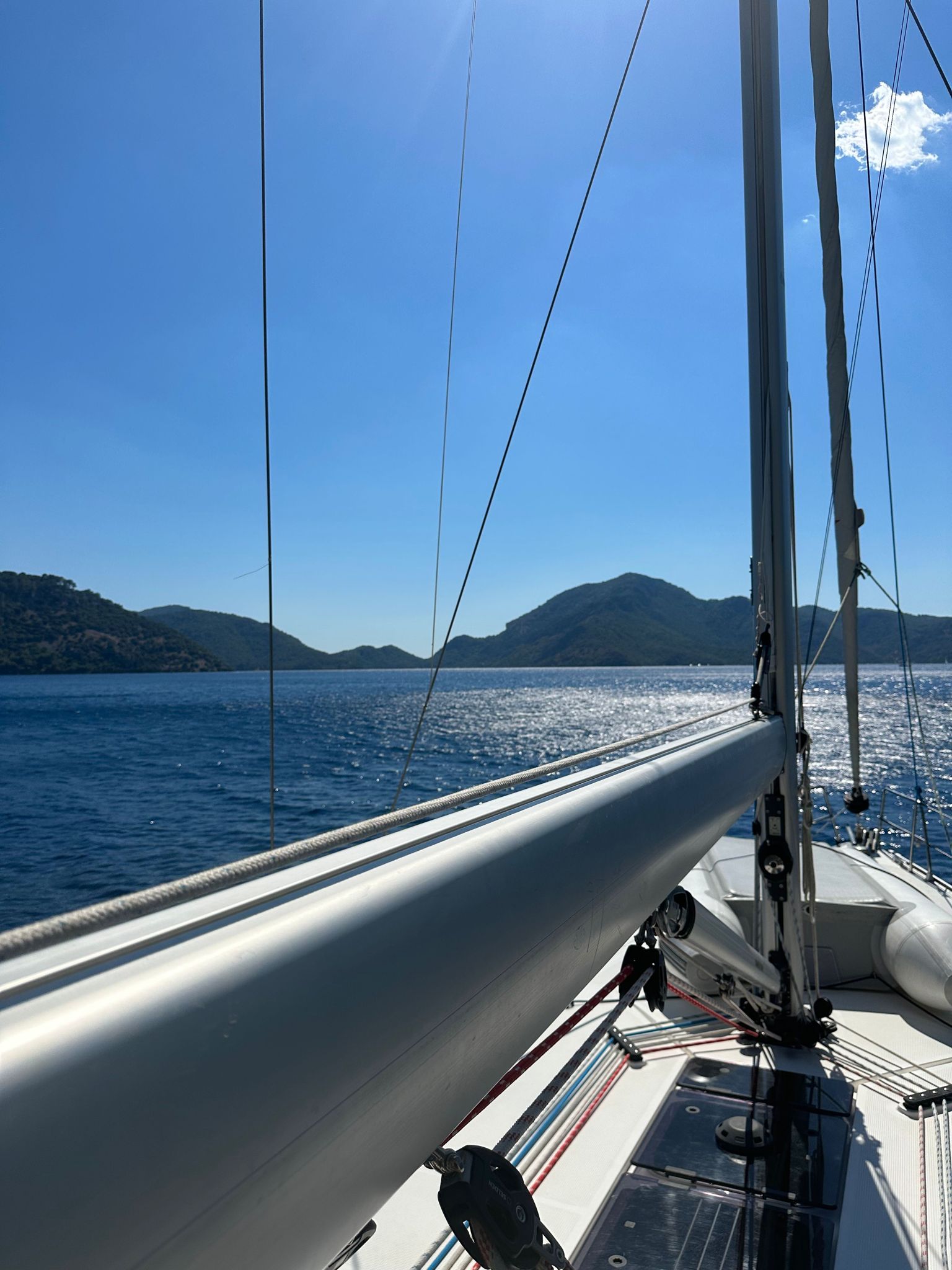 View from the deck of a yacht sailing the Turkish coast - boom, rigging, and mountains
